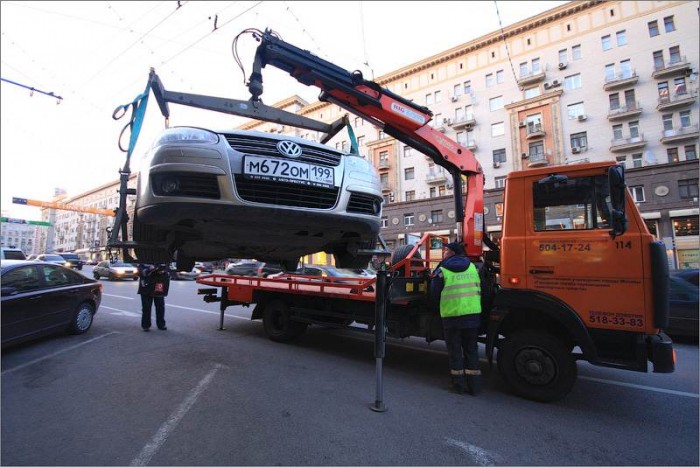 Эвакуатор поднимает авто